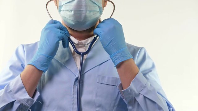 Young doctor hold stethoscope in hand in blue gloves and doing thumbs up