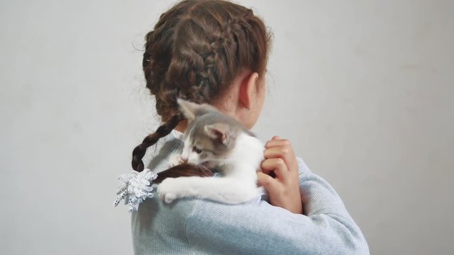 little girl holding a cat in her arms. kosh and girl pet friendship care and love. children and pets cat lifestyle concept