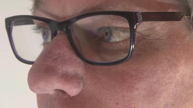 Close up of his face and his glass