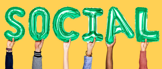 Green alphabet helium balloons forming the text social