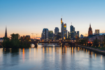 Fototapeta na wymiar View of Frankfurt am Main skyline at dusk along Main river with cruise ship in Frankfurt, Germany