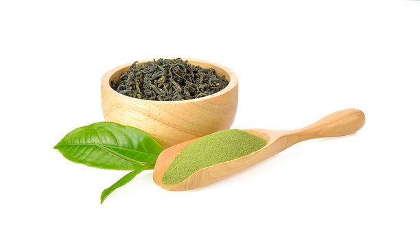 Green tea powder and dried leaves on white background
