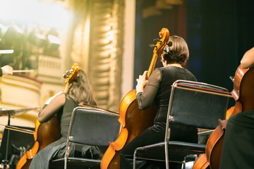 Musician play violin. Female violinist playing the violin stringst on the concert stage. Closeup.