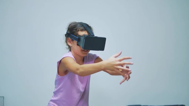 Happy young little girl using 3d goggles a virtual reality headset. Surprised woman with VR device. Happy smiling girl with virtual reality glasses on head. entertainment lifestyle virtual reality
