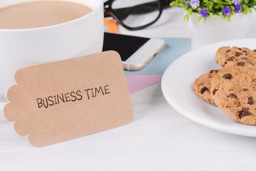 Paper card with "business time" text and coffee with phone, cookies and glasses