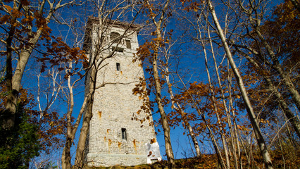 old stone tower in autumn park, no people, sunshine, peaceful