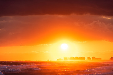 Dramatic orange red sunset in Santa Rosa Beach, Florida with Pensacola coastline coast cityscape...