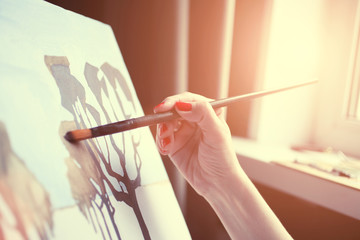 Woman draws an abstract picture near the window