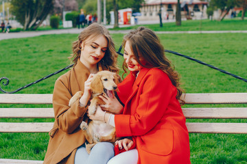 The girls are walking in the park with dog