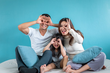 Portrait happy Asian family over blue background