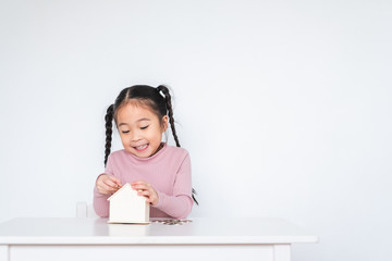 Asian girl kid, insert coin to deposit box, saving money concept over white background