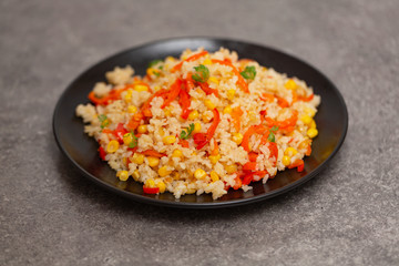 Chinese fried rice with vegetables, served on a plate with chopsticks. Selective focus