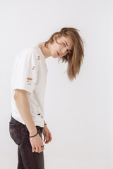 Handsome young guy posing in studio against isolated background. Fashion portrait of young man in stylish white t-shirt