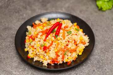 Chinese fried rice with vegetables, served on a plate with chopsticks. Selective focus