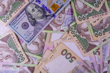 American one hundred dollars banknote on the many ukrainian hryvnas