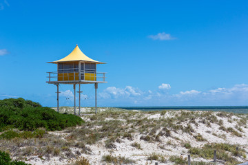 The iconic yellow lifeguard tower at Semaphore with blue skies and fluffy clouds at Semaphore South Australia on 7th November 2018