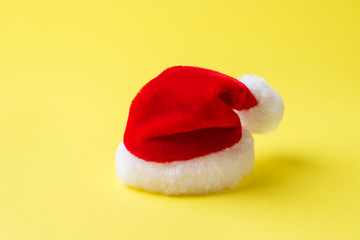 Obraz na płótnie Canvas Christmas new year concept. Santa's red hat on yellow background. Copy space