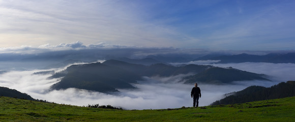 Man hiking on background of misty autumn mountains