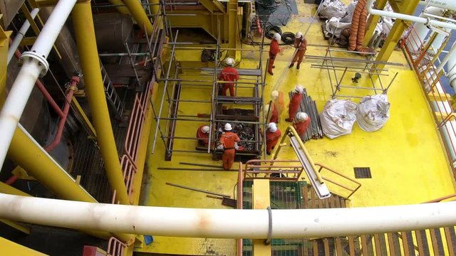 Top view of 4K time lapse scaffolder team perform scaffolding activities on gas platform in the middle of the sea.