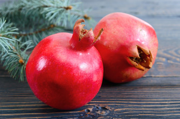 Ripe pomegranate fruit close up on wooden background. Healthy eating concept