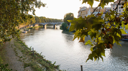 Beautiful ancient bridge over the calm river in the central part of Rome