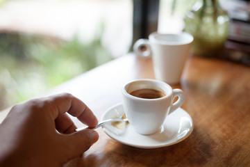 Cup of hot espresso coffee on wooden table.