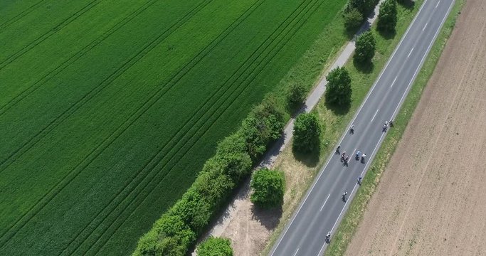Luftaufnahme - autofreie Landstraße mit Radfahrern - heranfliegen
