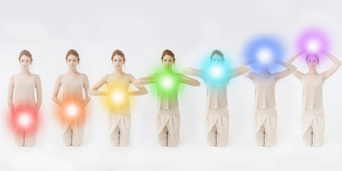 Woman meditating. Colored chakra lights over her body. Yoga, zen, Buddhism, recovery and wellbeing...