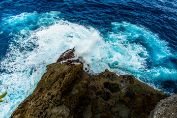 Ocean waves crashing cliff and rocks.