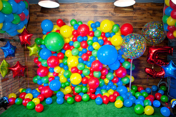 Fototapeta na wymiar Photo zone for children's birthday decorated with bright multi-colored balloons.