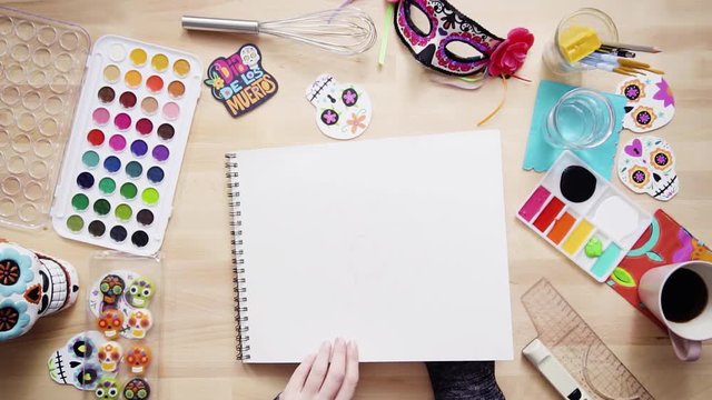 Step by step. Flat lay. Baker sketching a design of a cake for Dia de los Muertos holiday.