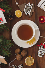 The winter holidays. Christmas tree toys on a brown wooden table. Happy New Year. Hot cup of tea. Top view