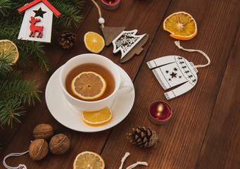 The winter holidays. Christmas tree toys on a brown wooden table. Happy New Year. Hot cup of tea....