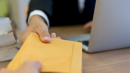 close up businessman hand sending or receive secret tan envelope form partner in private room ,...
