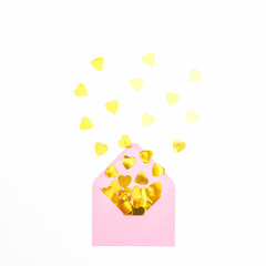 Festive composition with pink envelope and golden confetti on white background. Flat lay, top view.