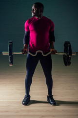 Black african american athletic man running on treadmills idoing exercises on muscle groups push up from the bench gym on black background