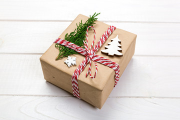 Christmas gift box wrapped in recycled paper, with ribbon top view with copy space on rustic background. Holiday concept