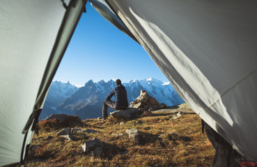 Hiker enjoying the mountain view in front of his tent. Chamonix, France.