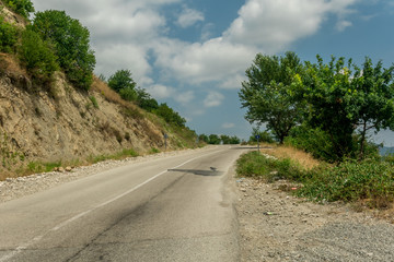 Fototapeta na wymiar Empty Highway asphalt way with rocky hill and trees.