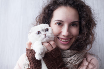 Young lady kissing cat at home. Funny cat