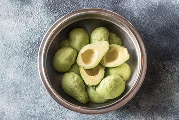 Halved avocados in the metal bowl