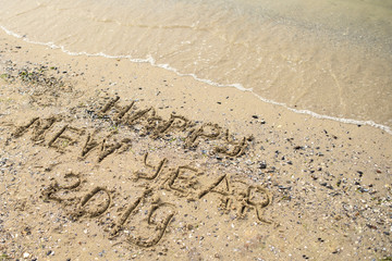 Happy new year 2019 written on tropical beach sand, copy space. Holiday concept