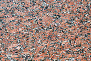 The flat surface of a natural marble or brown granite slab. On the surface there are many small cracks, streaks, stripes and dots. Background, Wallpaper or backdrop. Natural material.