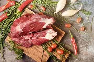 Fresh dark meat with ingredients for cooking on brown wooden cutting board. Hunting composition. Wildanimal hunting.