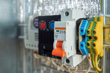 In the electrical Cabinet circuit breaker, thermostat, terminals. Modern reliable equipment to control the engine or pump or fan. There is adjustment on the thermostat. Shallow depth of field.