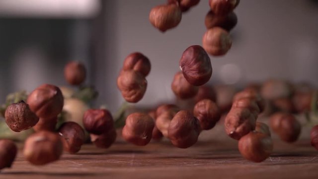 hazelnuts falling on cutting wood board ,slow motion 240 fps, shot on sony rx 10
