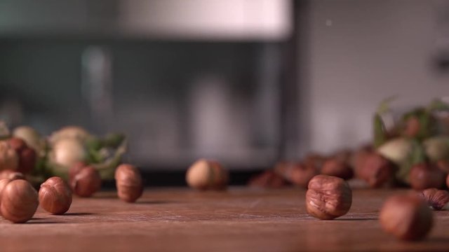 hazelnuts falling on cutting wood board ,slow motion 240 fps, shot on sony rx 10