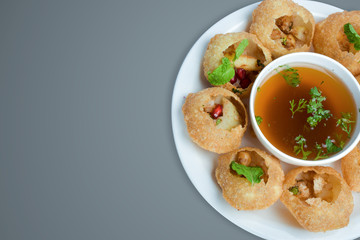 Delicious favorite north and south indian street food pani puri gol gappa with tamarind water served in white plate with mashed potato and chickpeas - obrazy, fototapety, plakaty