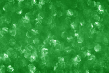 Green glitter sparkling background. Shiny glam abstract texture, defocused