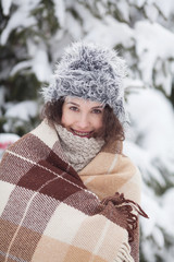 Beautiful winter portrait of young woman in the winter snowy scenery.